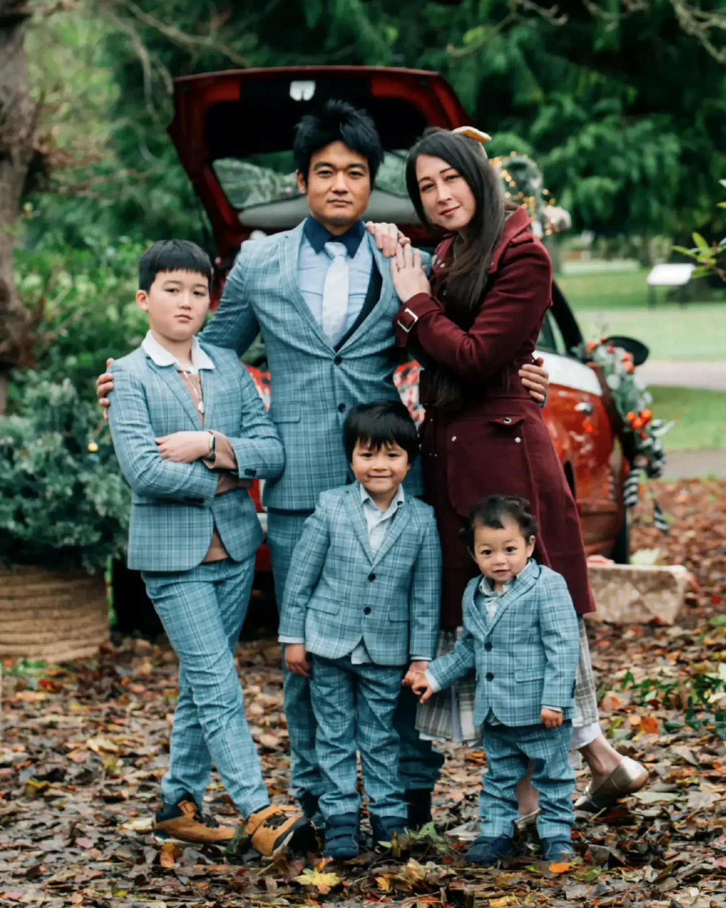 Zoe, Wing and their three children outdoors among autumn leaves