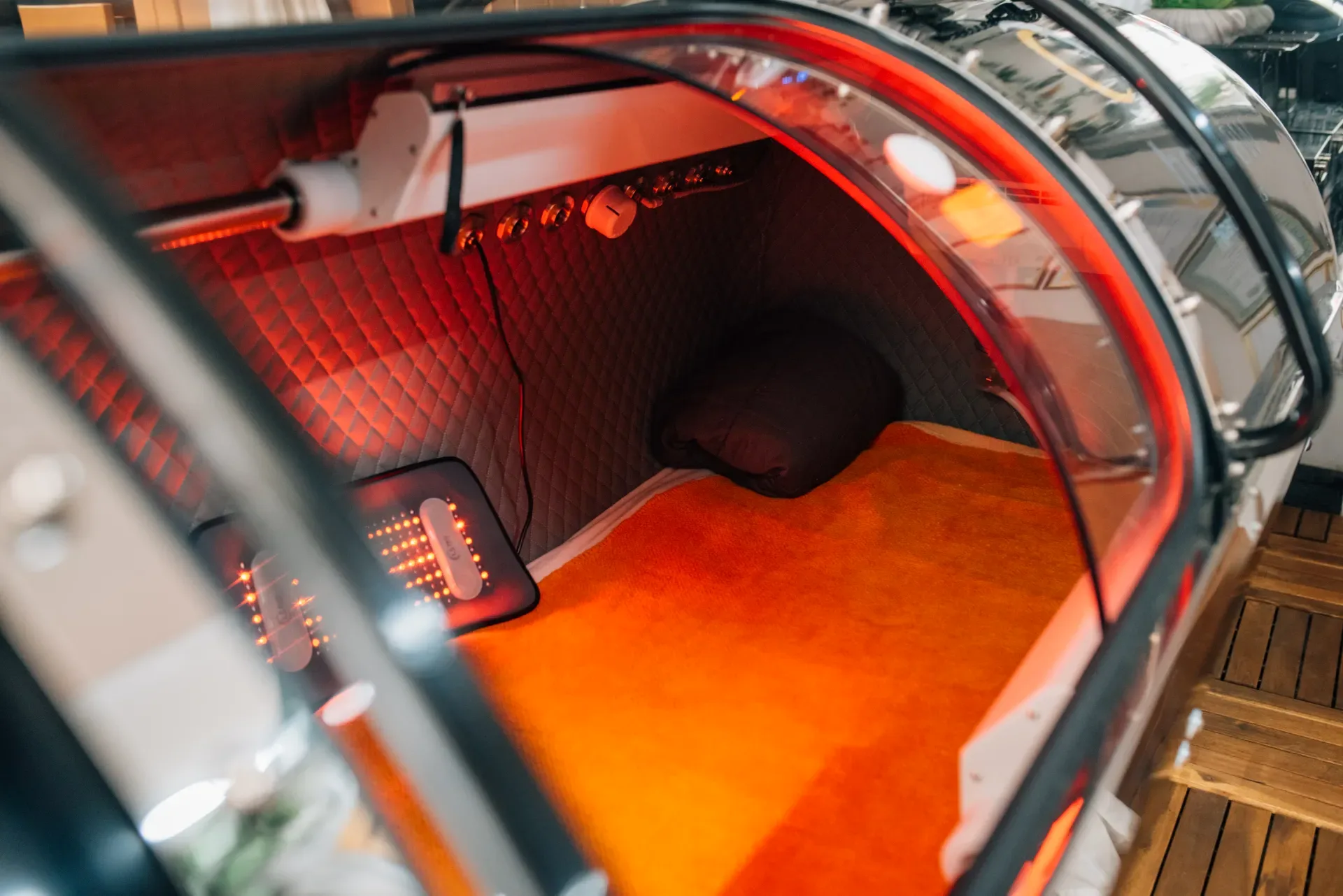 Red light glows inside a hyperbaric chamber during a recovery session
