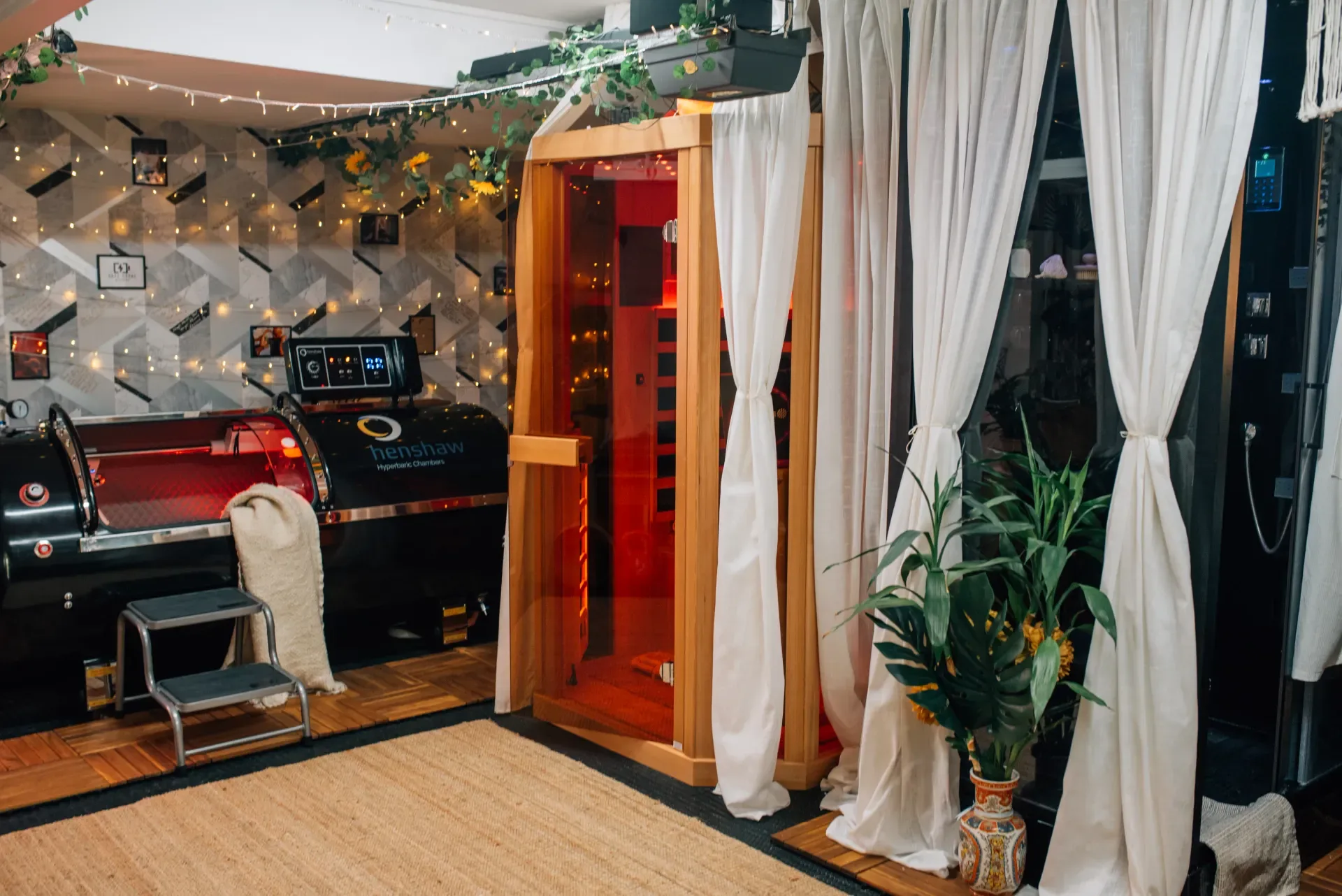 Treatment suite with a hyperbaric chamber, infrared sauna, and warm lighting